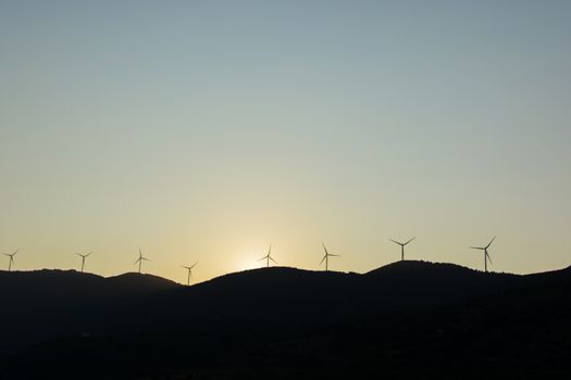 wind turbines in the mountains at sunset. wind turbines for generating electricity. mechanical power turns into electricity