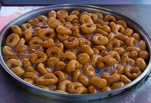 "Lokma" dessert; Prepared with flour, yeast, salt and sugar, prepared by frying in oil and sweetened with dark-colored syrup.