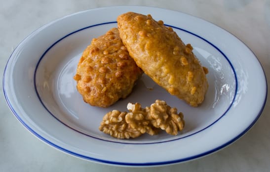 "kalburabastı" dessert;sherbet turkish sweet. For the dough, margarine, flour, yoghurt, oil, eggs, baking soda, walnuts are used. the colander is shaped by pressing