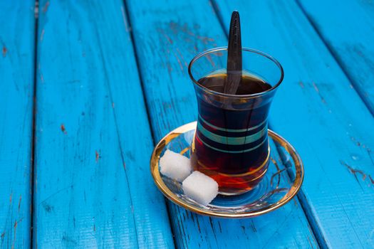 Black Turkish tea. Turkish national drink. well-brewed tea; It is called rabbit blood. isolated blue background. side view. Free space for your text