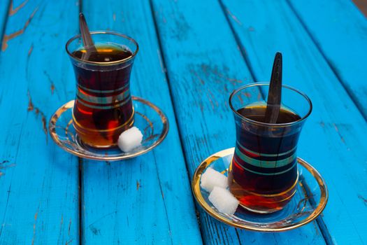Black Turkish tea. Turkish national drink. well-brewed tea; It is called rabbit blood. isolated blue background. side view. Free space for your text