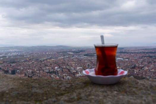 tea enjoyment. enjoying a hot tea while watching the city view from the top
