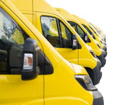 Detail on yellow vans lined up and parked in a long row isolated on white background. Delivery trucks fleet.