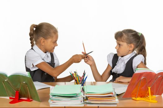 Two girls fight with pencils at a school desk