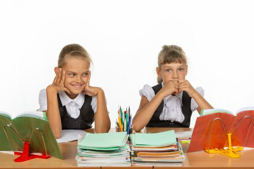 Girls in different emotions think about something while sitting at a desk at school