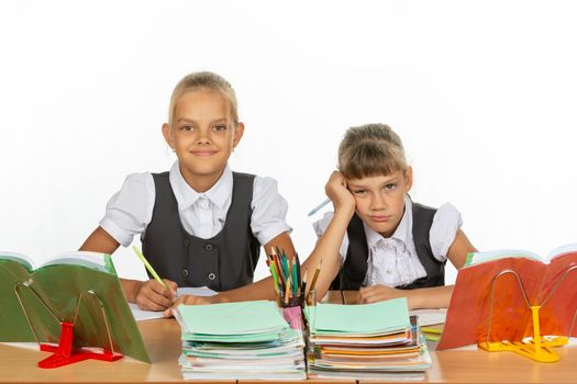 Two schoolgirls at a desk, one funny, the other upset