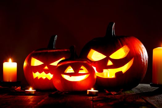 Halloween pumpkin head jack o lantern and candles on gray background