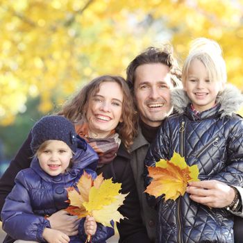Portrait of happy smiling family of parents and children in autumn park