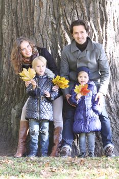 Happy smiling family of parents and children in autumn park