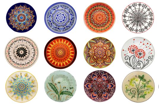 Set of decorative ceramic dishes hand-painted with acrylic paints floral pattern isolated on white background.