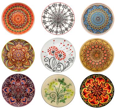 Set of decorative ceramic dishes hand-painted with acrylic paints floral pattern isolated on white background.