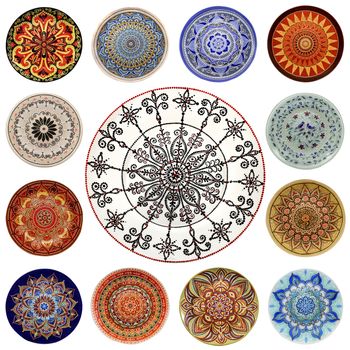 Set of decorative ceramic dishes hand-painted with acrylic paints floral pattern isolated on white background.