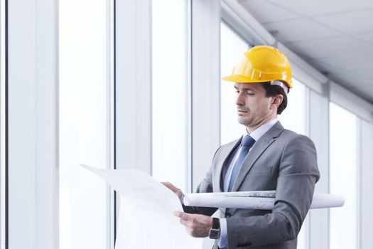 Architector in hardhat and business suit with construction plans