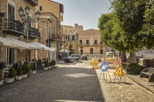 View of some historic buildings in the square of the Sicilian village of Butera with work in progress