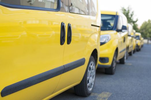 Yellow fleet cars parked in a line. Lined up pick-ups cars