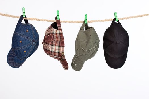 Different hats and caps hanging on a clothesline