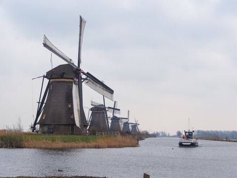 Netherlands rural landscape with windmills and canal at famous tourist site Kinderdijk in Holland