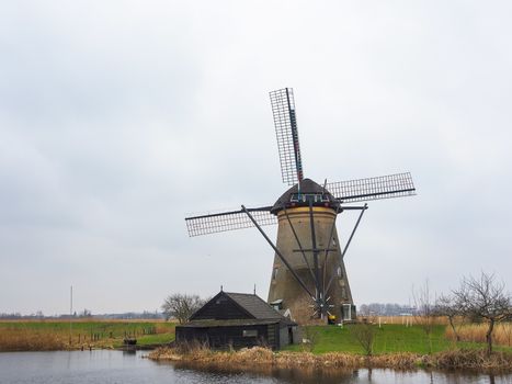 Netherlands rural landscape with windmills and canal at famous tourist site Kinderdijk in Holland