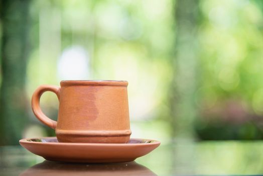 Coffee cup in green garden background - coffee with nature background concept