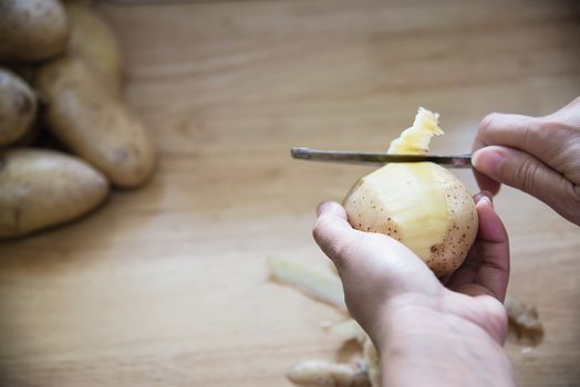 People cooking fresh potato preparing food in the kitchen - potato cooking concept