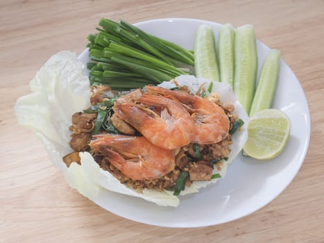 Fried noodle Thai style with prawns and fresh vegetable called "Pad Thai Goong Sod" - famous Thai style food recipe concept