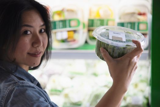 Lady is shopping fresh vegetable in supermarket store - woman in fresh market lifestyle concept