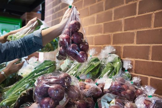 Lady is shopping fresh vegetable in supermarket store - woman in fresh market lifestyle concept