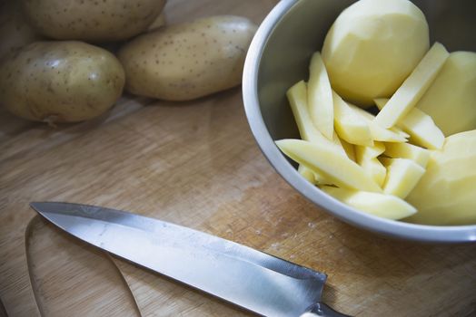 Fresh raw potato stick prepared for cooking in the kitchen - potato cooking concept