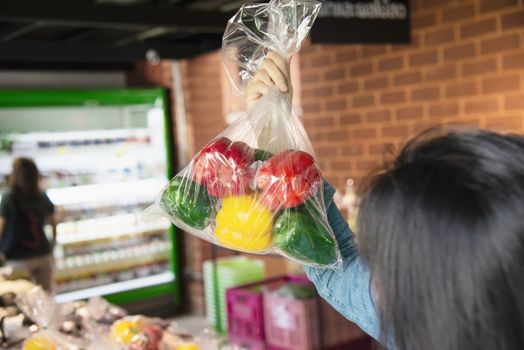 Lady is shopping fresh vegetable in supermarket store - woman in fresh market lifestyle concept