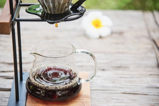 Man making drip fresh coffee in vintage coffee shop with green nature background - people with fresh coffee in nature concept