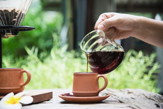 Man making drip fresh coffee in vintage coffee shop with green nature background - people with fresh coffee in nature concept