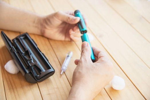 Man preparing insulin diabetic syringe for injection - people diabetic health care concept