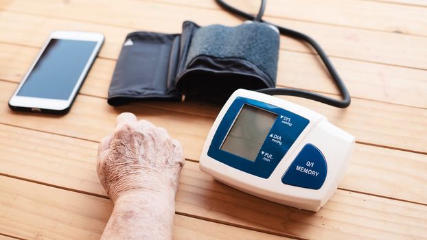 Old lady is being checked blood pressure using blood pressure monitor kid set - people with health care medical instrument set concept