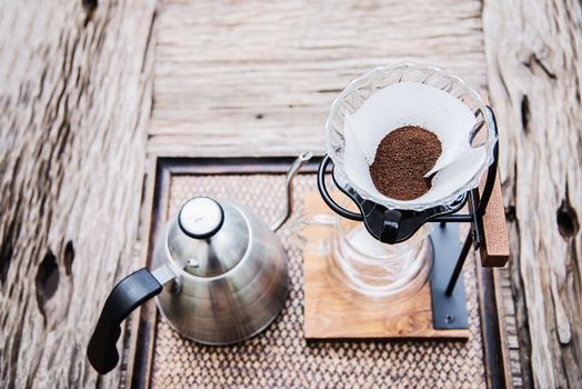 Making drip coffee in vintage coffee shop with green garden nature background - fresh coffee in nature concept