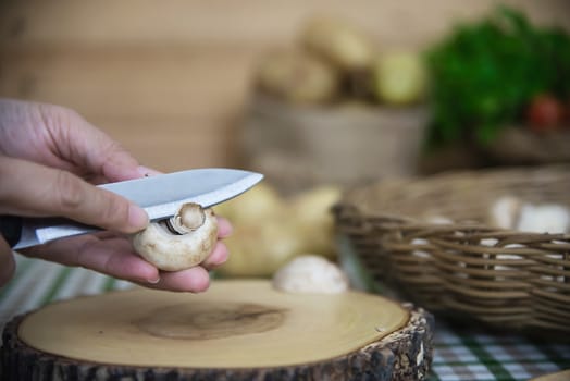 Lady cooks fresh champignon mushroom vegetable in the kitchen - people with vegetable cooking concept