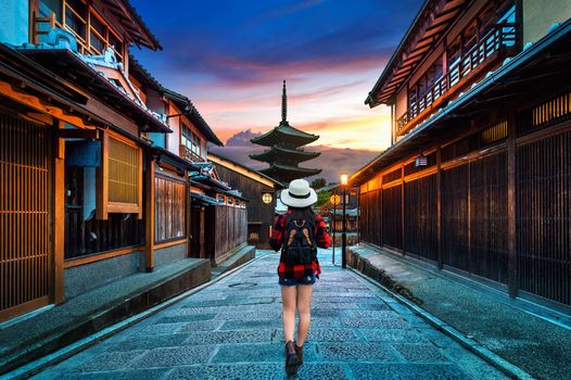 Woman traveler with backpack walking at Yasaka Pagoda and Sannen Zaka Street in Kyoto, Japan.