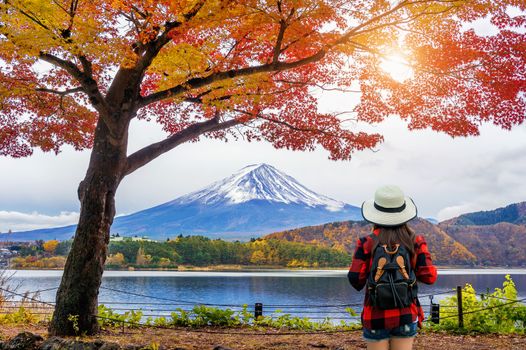 Woman traveler with backpack looking to Fuji mountains in Autumn, Japan.
