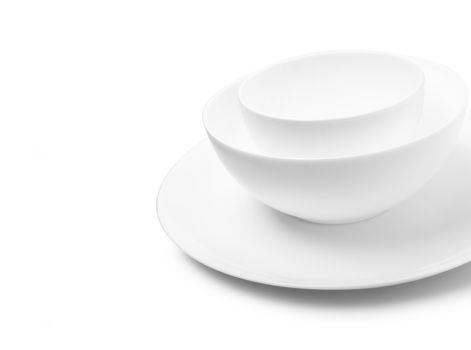 Set of white dishes on table on light background. With clippig path