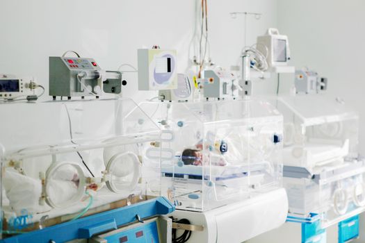 Newborn baby in hospital incubator.