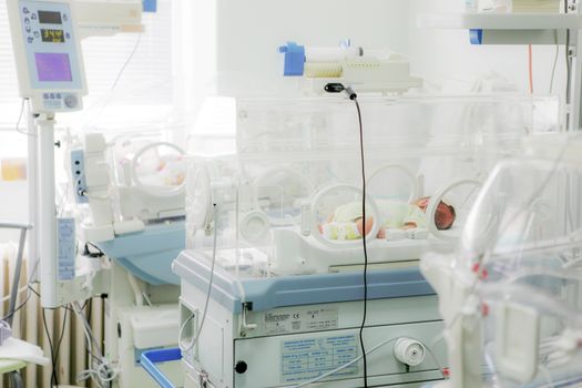 Newborn baby in hospital incubator.