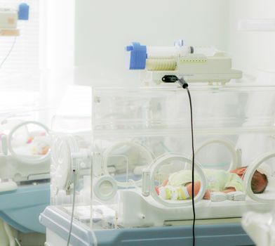 Newborn baby in hospital incubator.