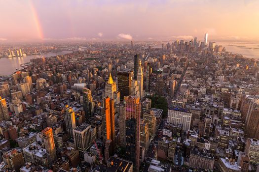 New York City skyline with Manhattan skyscrapers at dramatic vibrant after the storm sunset, USA. Rainbow can be seen in background over Brooklyn bridge.