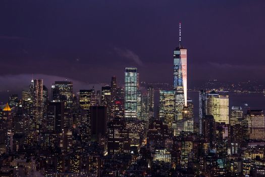 New York City skyline with lower Manhattan skyscrapers in storm at night.