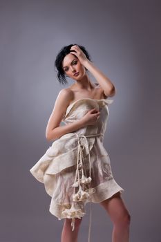 Young attractive woman dressed in handmade clothing on isolated background