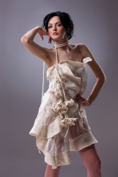 Young attractive woman dressed in handmade clothing on isolated background