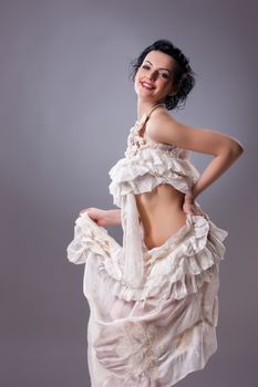 Young attractive woman dressed in handmade clothing on isolated background