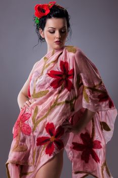 Young attractive woman dressed in handmade clothing on isolated background