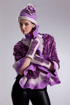 Young attractive woman dressed in handmade clothing on isolated background