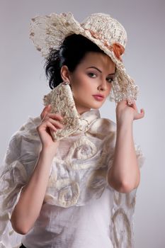 Young attractive woman dressed in handmade clothing on isolated background