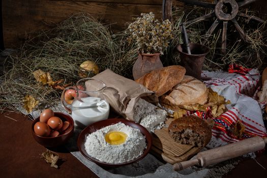 Different kinds of bread and rural accessories on a fabric background